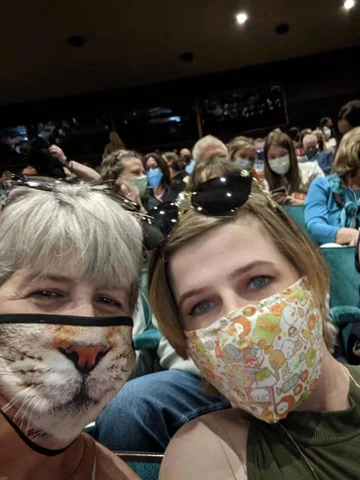 Two women wearing face masks together in a lecture hall